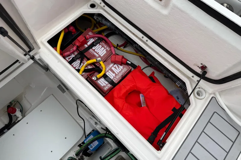  Yacht Photos Pics 2024 Solara S-250 Coupe storage compartment with batteries and a red life jacket.