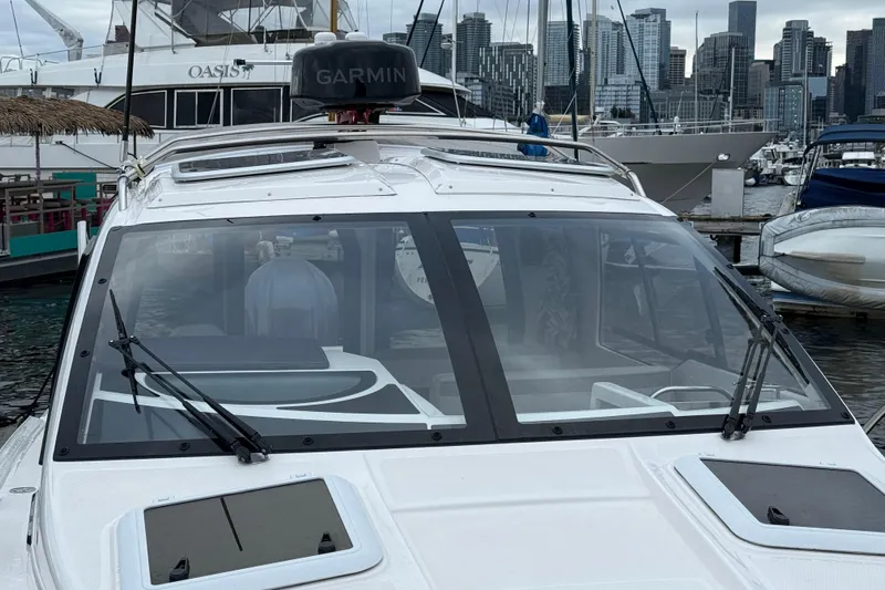  Yacht Photos Pics 2024 Solara S-250 Coupe boat docked at marina with city skyline in background.