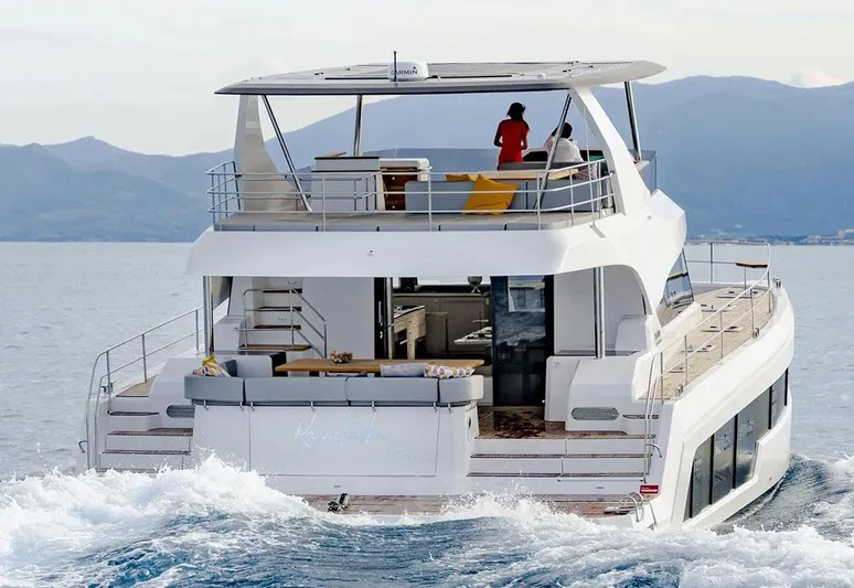  Yacht Photos Pics Aventura 56 Motor Yacht 2025 cruising on open water with passengers enjoying the view.