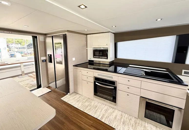 Yacht Photos Pics Modern kitchen interior of 2025 Aventura 56 Motor Yacht with sleek appliances and wood flooring.