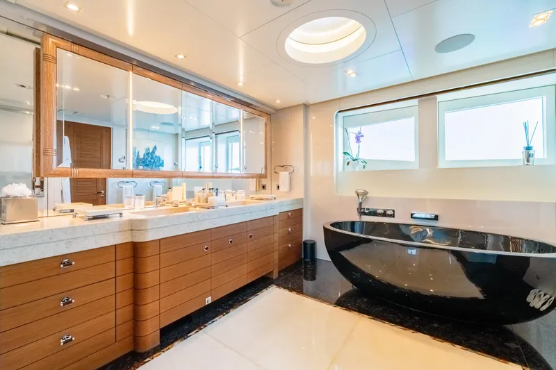 After You Yacht Photos Pics Luxurious yacht bathroom with black tub, wooden cabinetry, and large mirror on Heesen 55m, 2011 model.