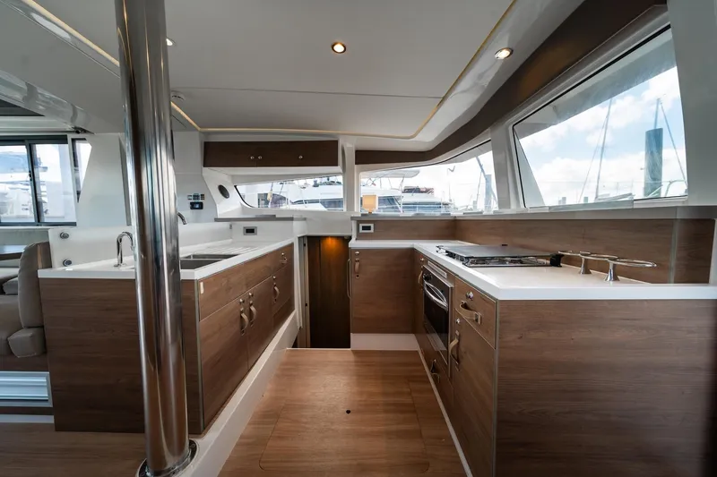 Cat Tales Yacht Photos Pics Modern kitchen interior on 2022 Bali 4.2 yacht, featuring wood cabinetry and stainless steel appliances.