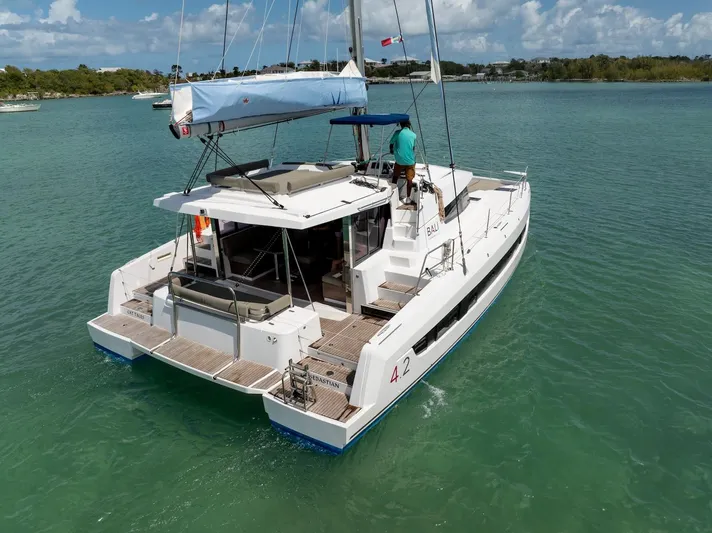 Cat Tales Yacht Photos Pics 2022 Bali 4.2 catamaran sailing on calm turquoise waters under a clear sky.