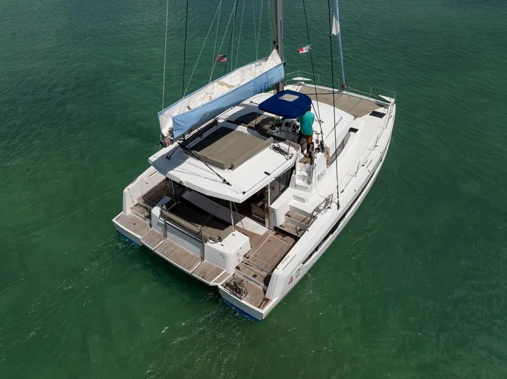 Cat Tales Yacht Photos Pics 2022 Bali 4.2 catamaran sailing on clear green water, aerial view.