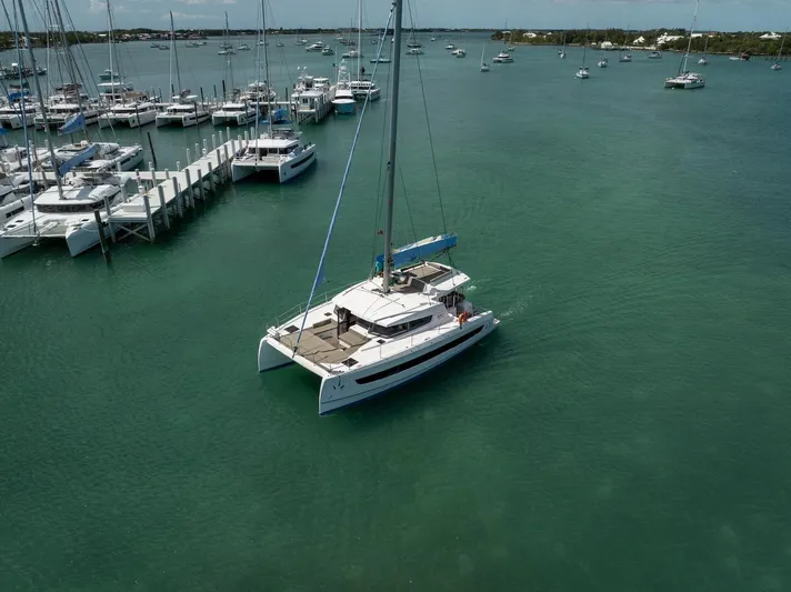 Cat Tales Yacht Photos Pics 2022 Bali 4.2 catamaran sailing near marina with multiple docked boats.