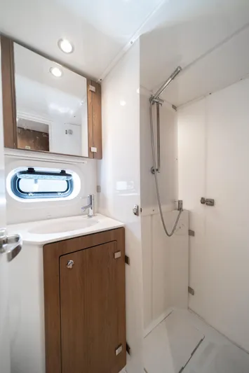 Cat Tales Yacht Photos Pics Modern bathroom in 2022 Bali 4.2 yacht with shower, sink, and wooden cabinetry.