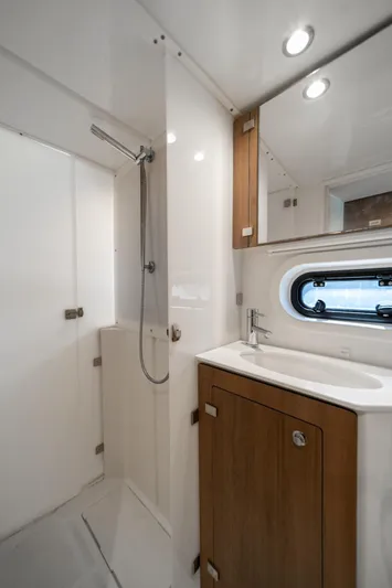 Cat Tales Yacht Photos Pics Modern yacht bathroom with shower, wooden cabinet, and porthole window in 2022 Bali 4.2 model.