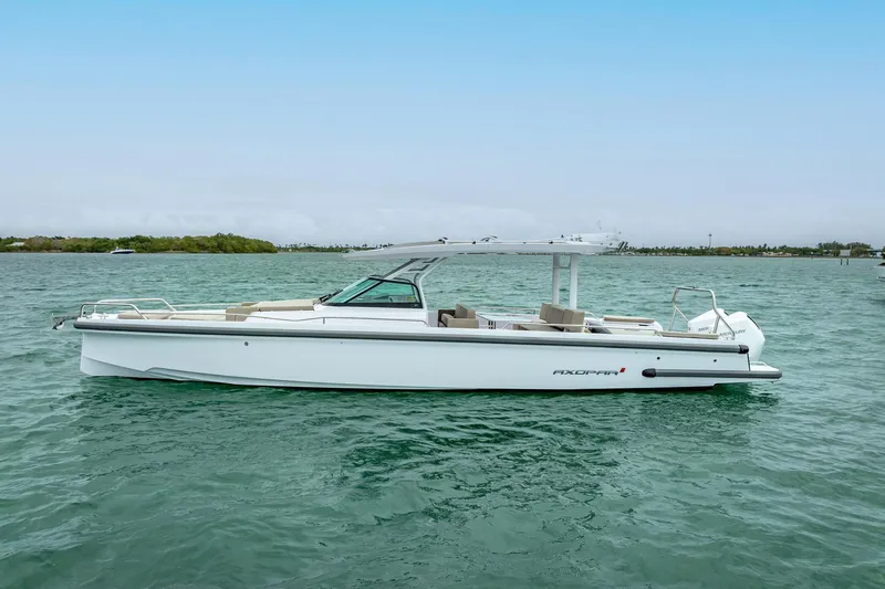  Yacht Photos Pics 2024 Axopar 37 Sun-Top boat on calm water, showcasing sleek design and modern features.