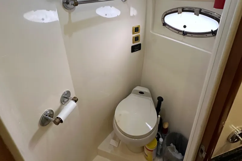  Yacht Photos Pics Compact bathroom in 2001 Carver 570 Voyager Pilothouse with toilet and porthole window.