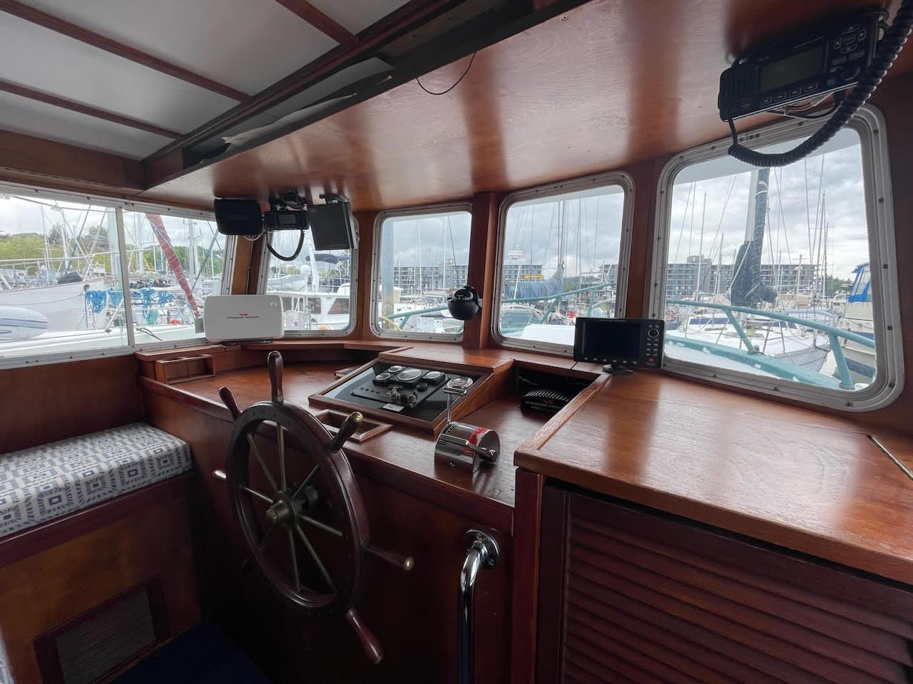 Interior of a 2010 custom trawler with wooden helm and navigation equipment.
