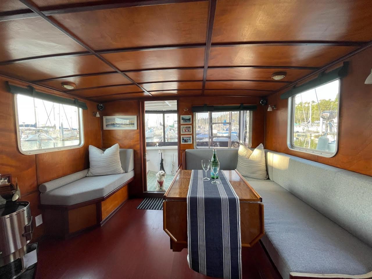 Cozy interior of a 2010 custom trawler with wooden paneling and comfortable seating.