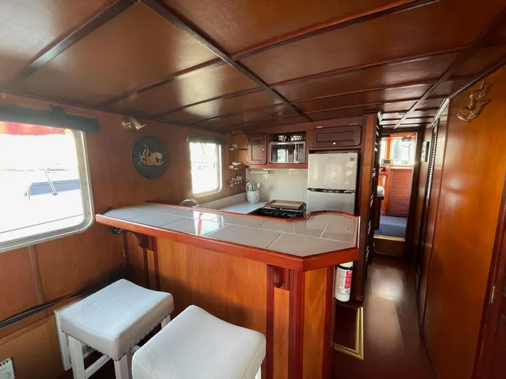 Sea Prince III Yacht Photos Pics Interior of a 2010 Custom Trawler with wooden decor and a compact kitchen area.