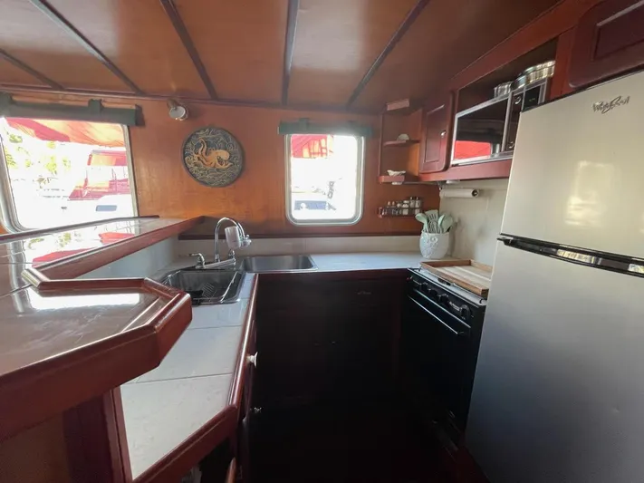 Sea Prince III Yacht Photos Pics Interior of a 2010 custom trawler kitchen with wooden cabinetry and modern appliances.