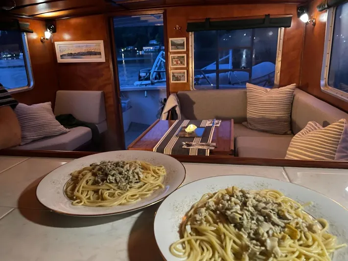 Sea Prince III Yacht Photos Pics Cozy trawler interior with pasta dishes, featuring a dining area and nautical decor.