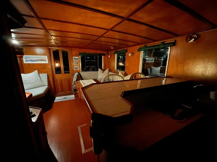 Sea Prince III Yacht Photos Pics Interior of a 2010 custom trawler with warm wood paneling and cozy seating area.