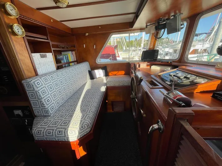 Sea Prince III Yacht Photos Pics Cozy 2010 custom trawler interior with patterned seating, wooden accents, and navigational equipment.