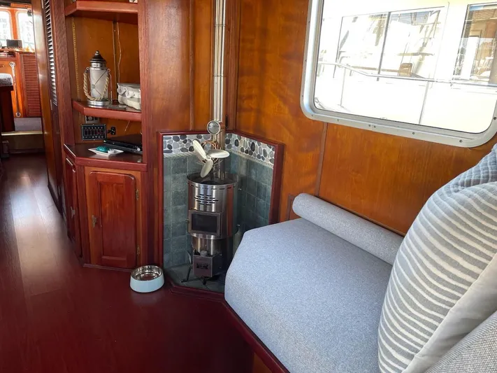 Sea Prince III Yacht Photos Pics Cozy interior of a 2010 custom trawler with wood paneling and a small stove.