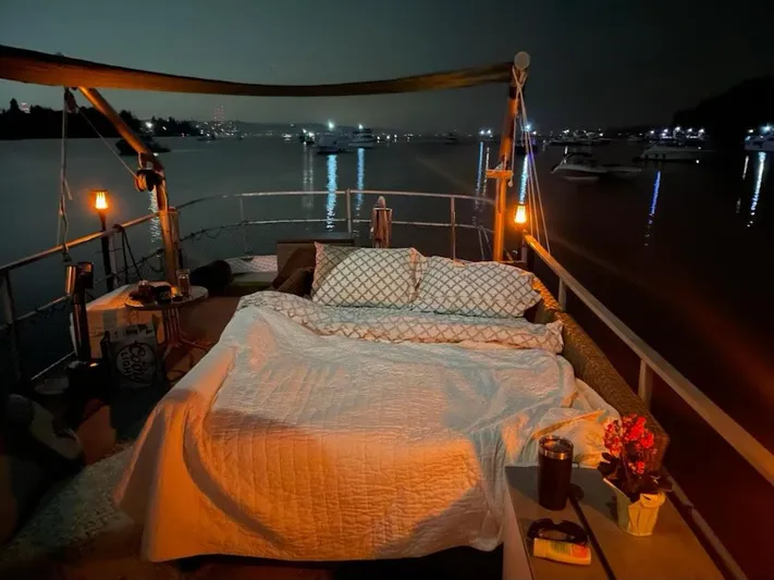 Sea Prince III Yacht Photos Pics Outdoor bed setup on a 2010 Custom Trawler, overlooking a serene night harbor.