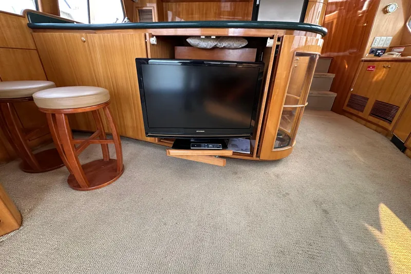 Sunchaser Yacht Photos Pics Interior of a 1999 Hampton 490 yacht with TV and wooden cabinetry.