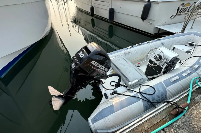 Sunchaser Yacht Photos Pics Inflatable boat with Mercury 30 outboard motor docked beside larger boats.