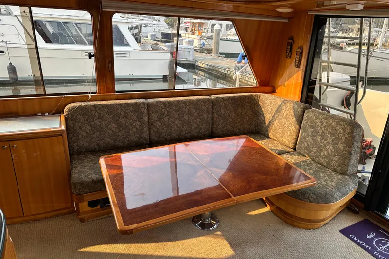 Sunchaser Yacht Photos Pics Luxurious 1999 Hampton 490 yacht interior with elegant wood table and plush seating.