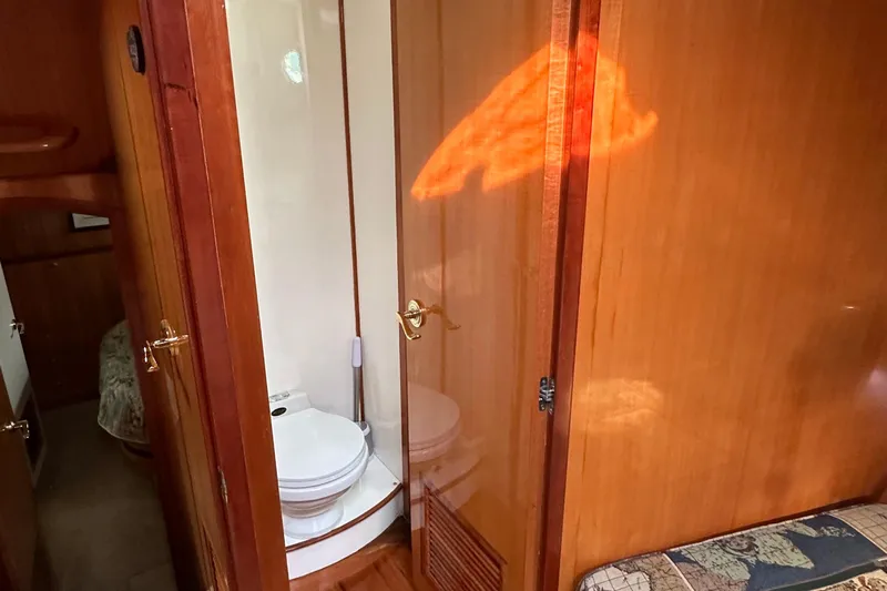 Sunchaser Yacht Photos Pics Interior of 1999 Hampton 490 yacht showing bathroom with wooden door and toilet.