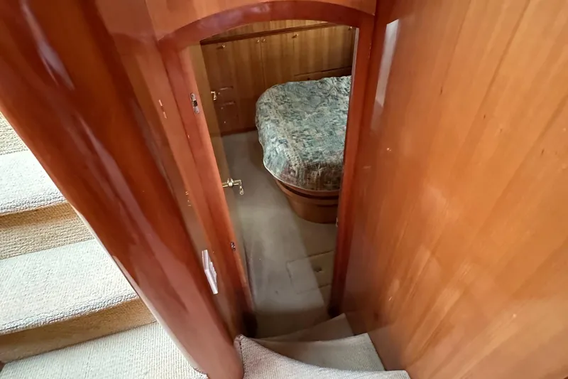 Sunchaser Yacht Photos Pics Interior view of a 1999 Hampton 490 yacht cabin with wooden finish and bed.