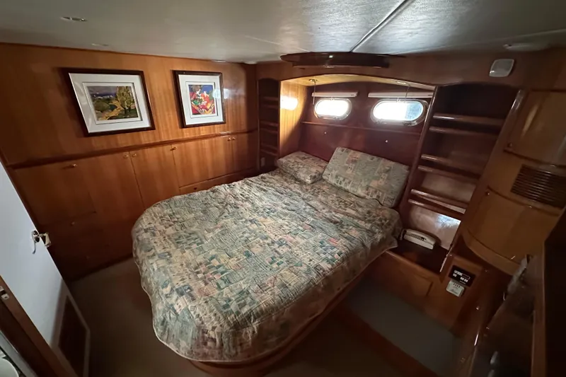 Sunchaser Yacht Photos Pics Cozy bedroom in 1999 Hampton 490 yacht with wood paneling and framed artwork.