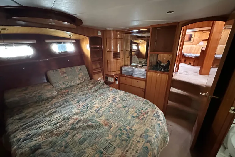 Sunchaser Yacht Photos Pics Luxurious 1999 Hampton 490 yacht bedroom with wood paneling and cozy bedding.