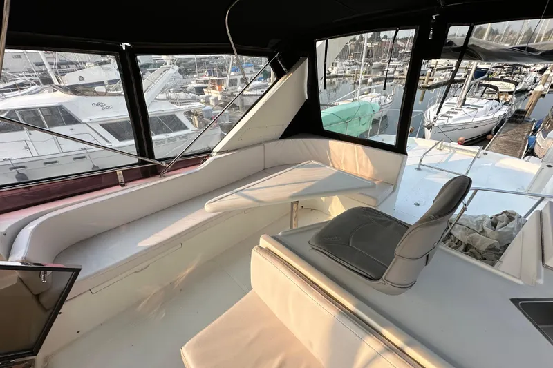 Sunchaser Yacht Photos Pics Interior view of a 1999 Hampton 490 yacht with seating and marina backdrop.