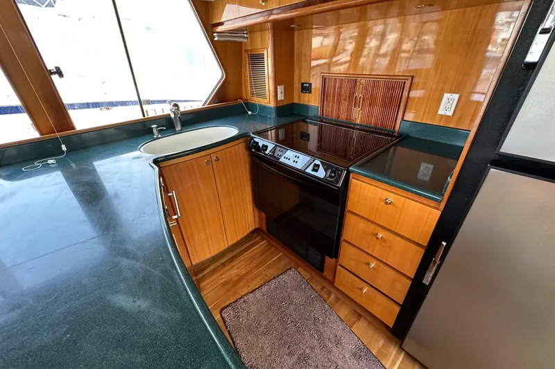 Sunchaser Yacht Photos Pics Luxurious 1999 Hampton 490 yacht kitchen with wood cabinetry and modern appliances.