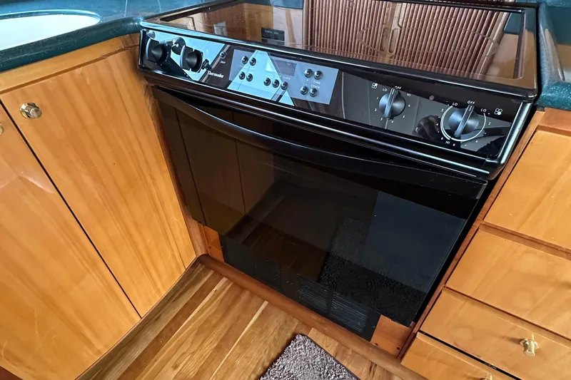 Sunchaser Yacht Photos Pics 1999 Hampton 490 kitchen with black oven and wooden cabinetry.