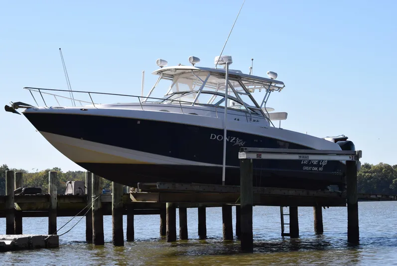 Tie Me Up Yacht Photos Pics 2005 Donzi 38 ZSF boat docked on a lift by the water.