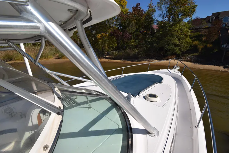 Tie Me Up Yacht Photos Pics 2005 Donzi 38 ZSF boat docked near a sandy shoreline with trees.