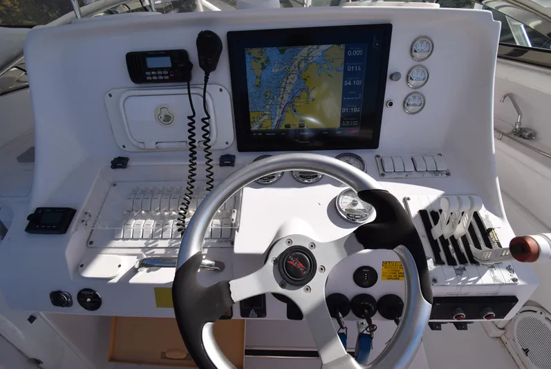 Tie Me Up Yacht Photos Pics Control panel of a 2005 Donzi 38 ZSF boat with navigation screen and steering wheel.