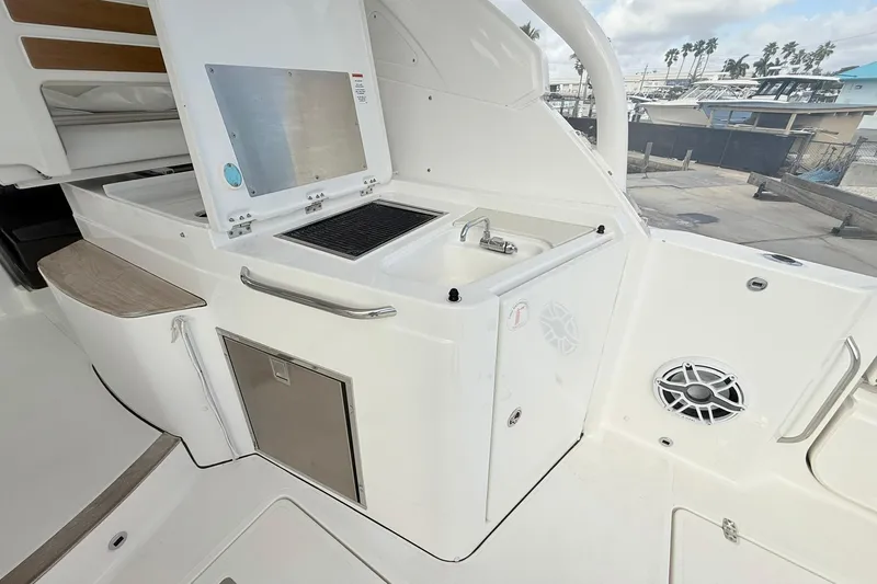 Salty Girl Yacht Photos Pics 2022 Pursuit DC 365 Dual Console boat kitchen area with sink and storage.