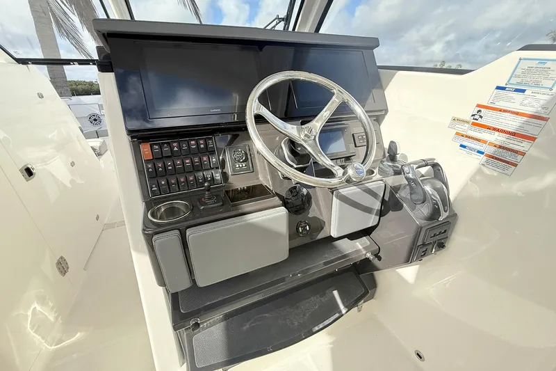 Salty Girl Yacht Photos Pics Helm of 2022 Pursuit DC 365 Dual Console with steering wheel and control panel.