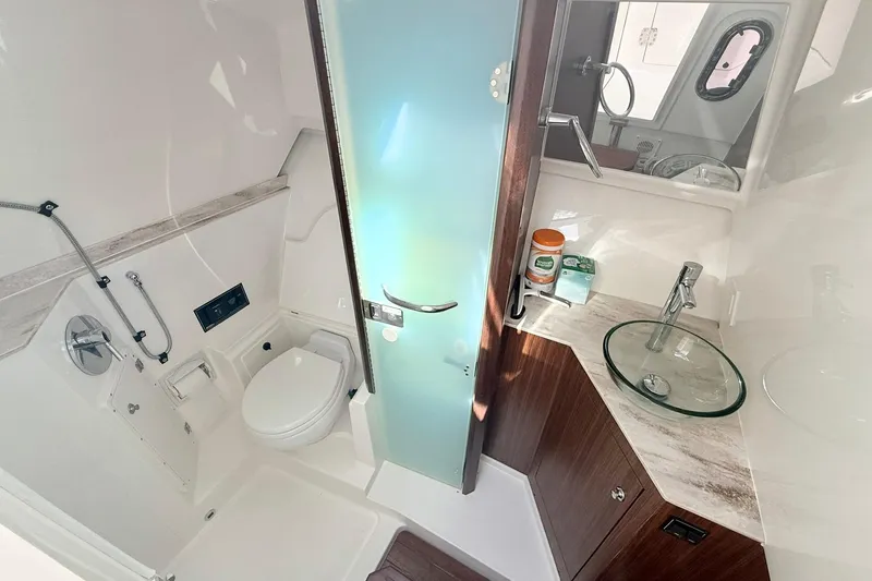 Salty Girl Yacht Photos Pics 2022 Pursuit DC 365 Dual Console boat bathroom with modern fixtures and glass sink.