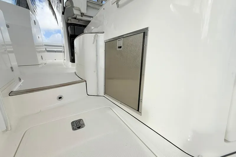 Salty Girl Yacht Photos Pics 2022 Pursuit DC 365 Dual Console boat interior with stainless steel storage compartment.
