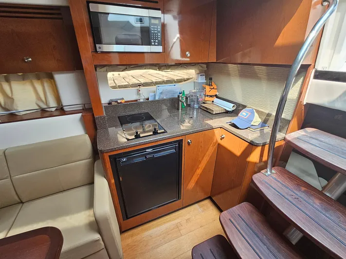 Knot On Call Yacht Photos Pics Interior of 2014 Sea Ray 350 Sundancer yacht kitchen with microwave, stove, and fridge.