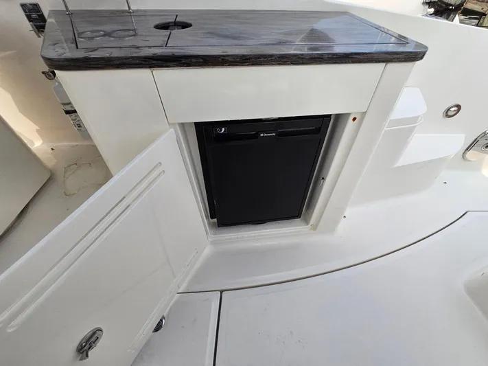 Knot On Call Yacht Photos Pics 2014 Sea Ray 350 Sundancer boat kitchenette with mini fridge and open cabinet.