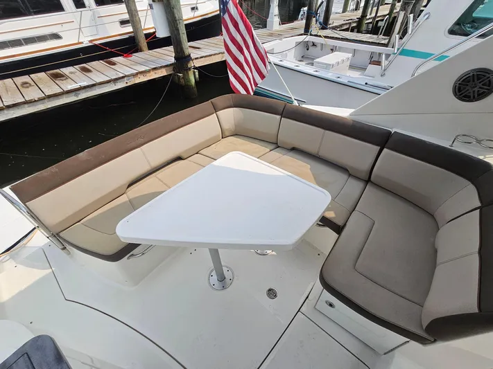 Knot On Call Yacht Photos Pics 2014 Sea Ray 350 Sundancer boat with cushioned seating and table, docked at marina.