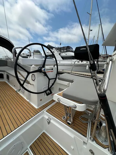 Edwina Yacht Photos Pics 2018 Jeanneau 54 yacht cockpit with steering wheel and teak flooring, docked at marina.
