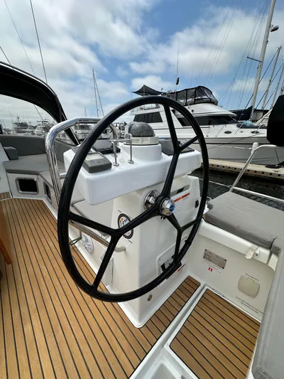 Edwina Yacht Photos Pics Steering wheel of a 2018 Jeanneau 54 yacht, docked at a marina.