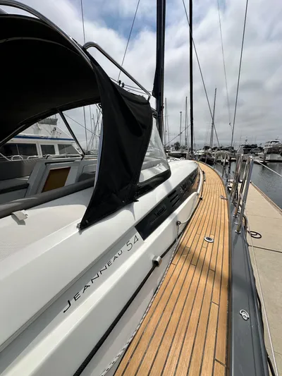 Edwina Yacht Photos Pics 2018 Jeanneau 54 yacht docked, showcasing sleek design and wooden deck.