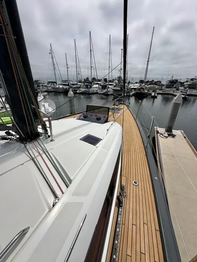 Edwina Yacht Photos Pics Jeanneau 54 sailboat, 2018 model, docked in marina with wooden deck and overcast sky.
