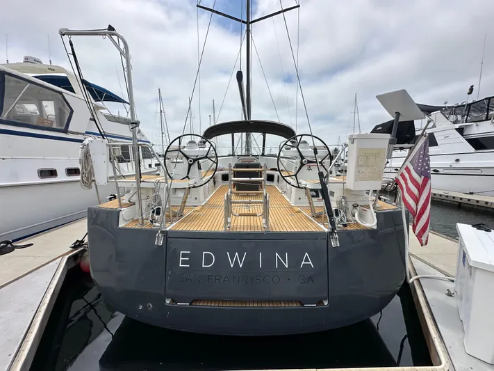 Edwina Yacht Photos Pics 2018 Jeanneau 54 yacht docked, displaying dual steering wheels and American flag.