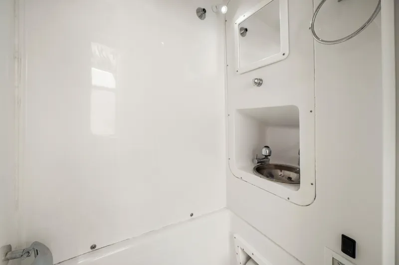  Yacht Photos Pics Compact bathroom in 2017 Midnight Express 43 Open boat, featuring a small sink and mirror.