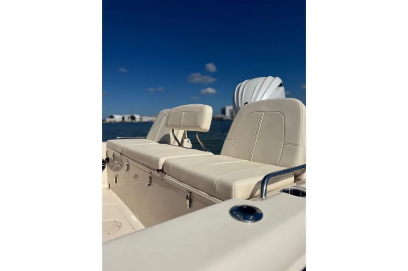 Yacht Photos Pics 2023 Grady-White 251 Coastal Explorer boat interior with beige seating, under clear blue sky.