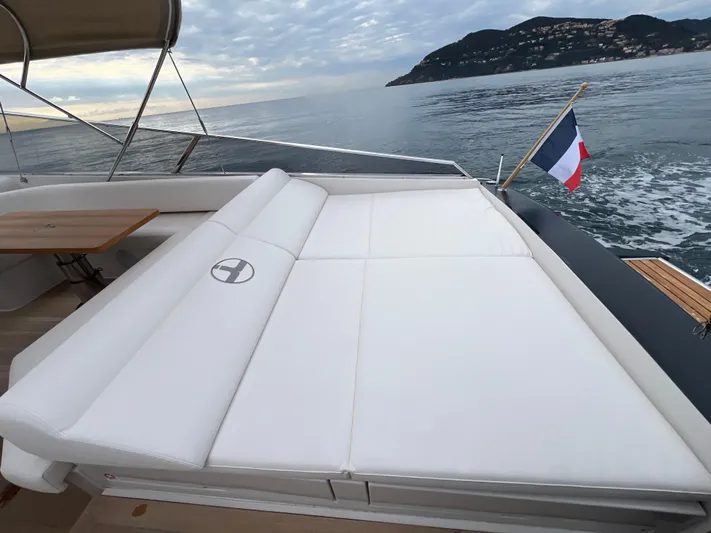Stanislas Michel Yacht Photos Pics Luxurious Itama 45 RS yacht deck with sunbed, French flag, and scenic ocean view.